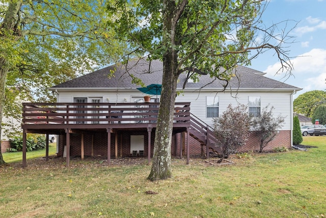 rear view of house featuring a lawn and a deck