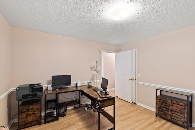 office with light hardwood / wood-style floors and a textured ceiling