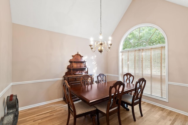 dining area with lofted ceiling, a notable chandelier, and light hardwood / wood-style floors