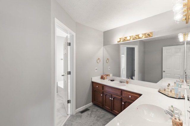 bathroom featuring a textured ceiling and vanity