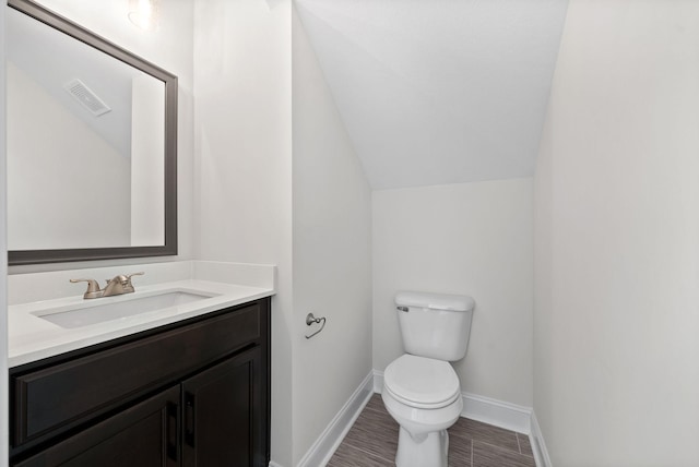 bathroom featuring lofted ceiling, vanity, and toilet