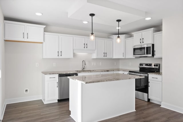 kitchen with white cabinetry, stainless steel appliances, decorative light fixtures, a kitchen island, and sink