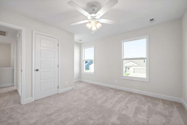 unfurnished bedroom with ceiling fan and light colored carpet