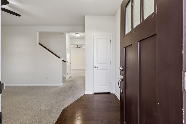 foyer entrance featuring ceiling fan and dark colored carpet