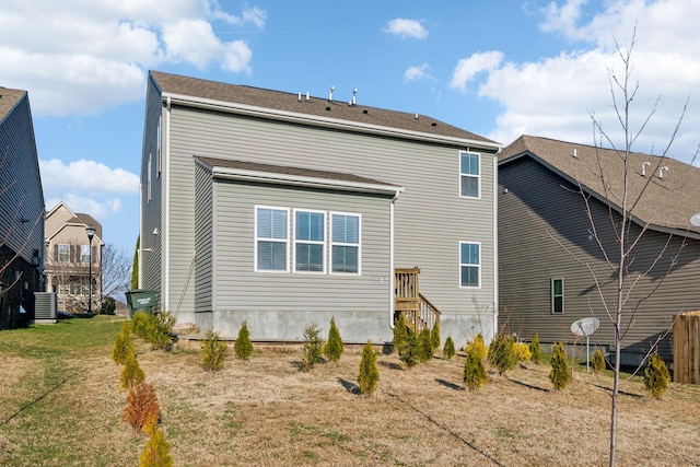 back of house featuring cooling unit and a yard