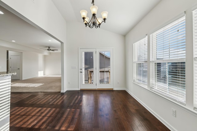 interior space with ceiling fan with notable chandelier, dark hardwood / wood-style floors, and vaulted ceiling