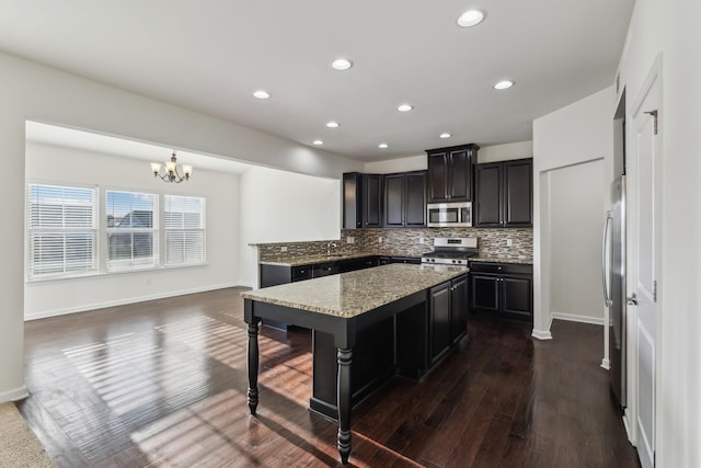 kitchen with decorative light fixtures, tasteful backsplash, a notable chandelier, dark hardwood / wood-style floors, and appliances with stainless steel finishes