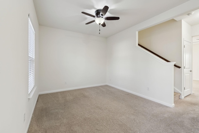 carpeted spare room featuring ceiling fan