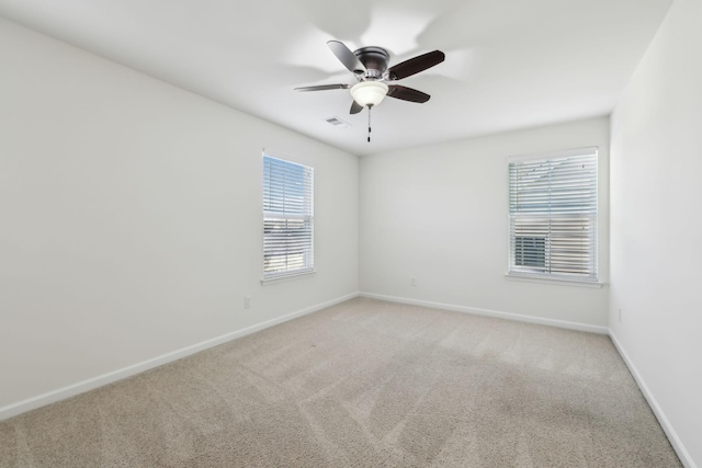 carpeted spare room featuring ceiling fan