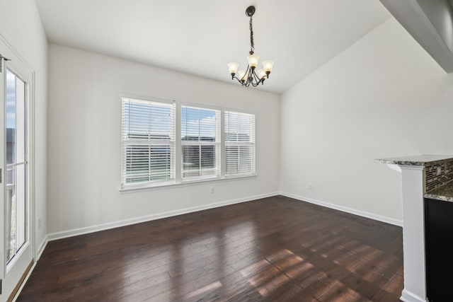 unfurnished dining area featuring dark hardwood / wood-style flooring and a chandelier