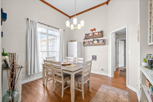 dining room with an inviting chandelier, crown molding, and hardwood / wood-style floors