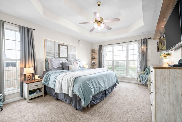 bedroom featuring ceiling fan, carpet, and a tray ceiling