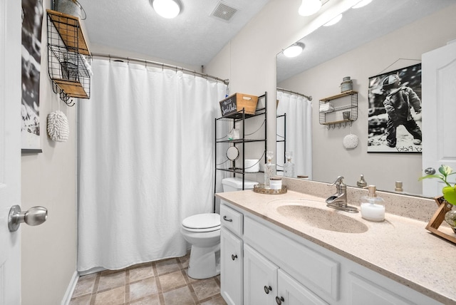 bathroom featuring a textured ceiling, toilet, and vanity