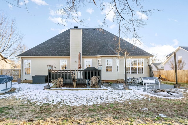 snow covered back of property with a swimming pool side deck