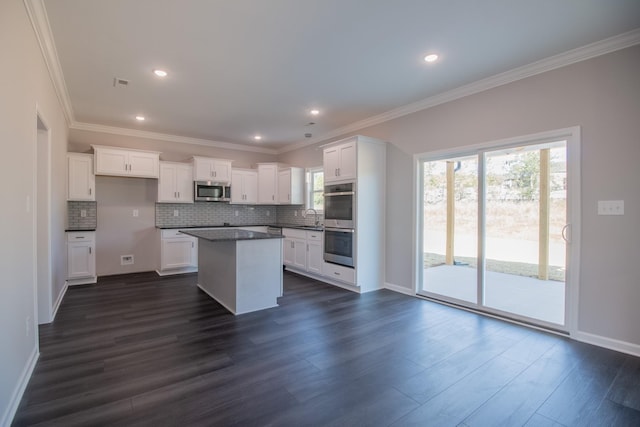 kitchen with appliances with stainless steel finishes, sink, white cabinetry, and dark hardwood / wood-style floors