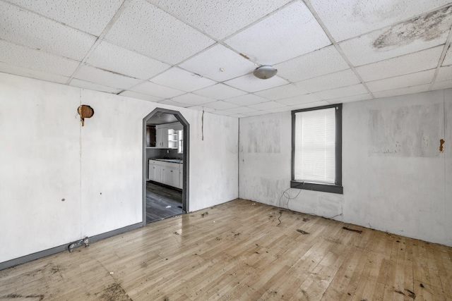 spare room with wood-type flooring and a drop ceiling