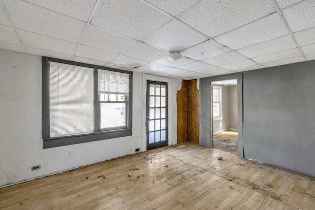 spare room with light hardwood / wood-style floors and a paneled ceiling