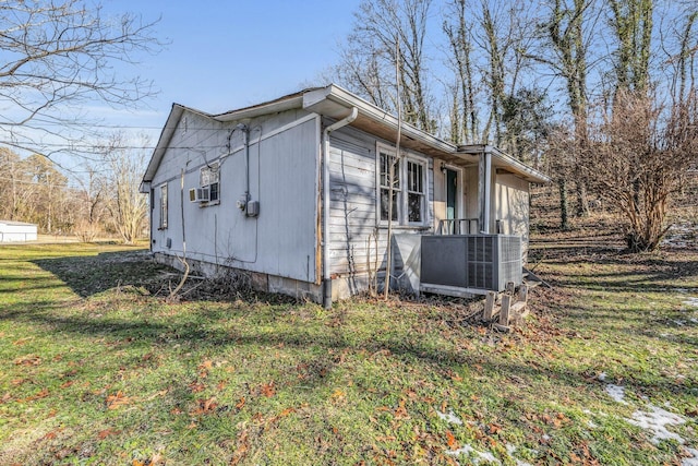 view of property exterior featuring central AC unit and a lawn