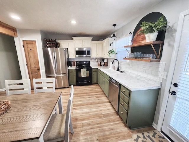 kitchen featuring pendant lighting, appliances with stainless steel finishes, tasteful backsplash, sink, and green cabinets