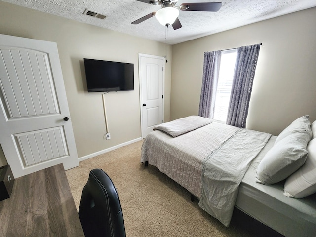 bedroom with a textured ceiling, ceiling fan, and carpet floors