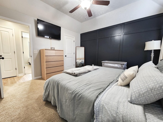 carpeted bedroom with ceiling fan and a textured ceiling