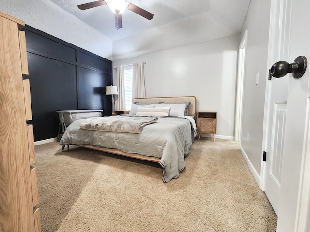 bedroom featuring a textured ceiling, lofted ceiling, carpet flooring, ceiling fan, and a tray ceiling