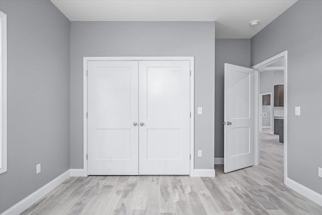 unfurnished bedroom featuring a closet and light hardwood / wood-style flooring