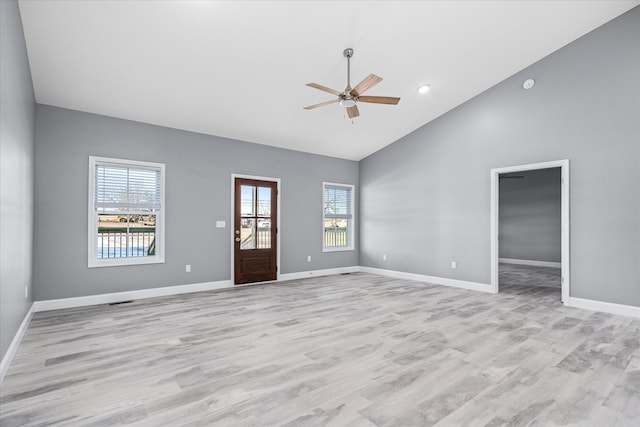 unfurnished living room featuring ceiling fan, high vaulted ceiling, and light wood-type flooring