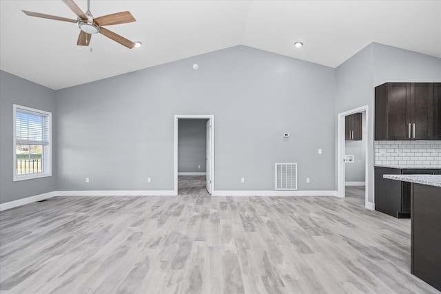 unfurnished living room featuring ceiling fan, high vaulted ceiling, and light wood-type flooring