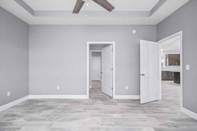 unfurnished bedroom with ceiling fan, a spacious closet, and light hardwood / wood-style floors