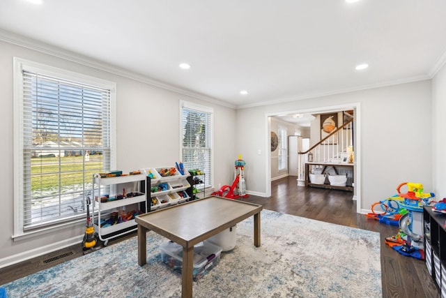 recreation room with dark hardwood / wood-style flooring and crown molding