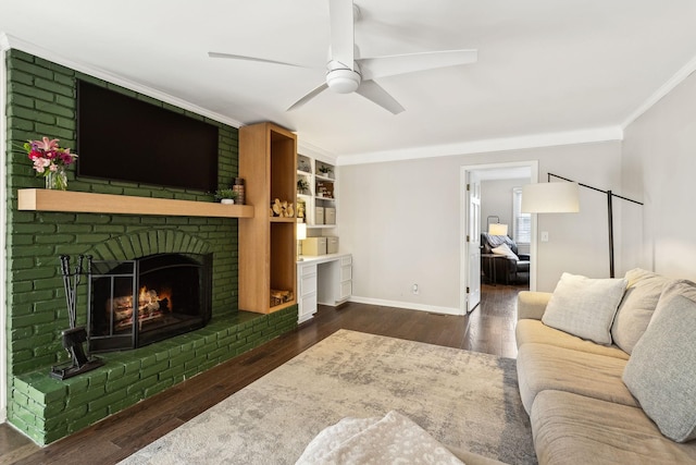 living room with ceiling fan, crown molding, a fireplace, and dark hardwood / wood-style floors