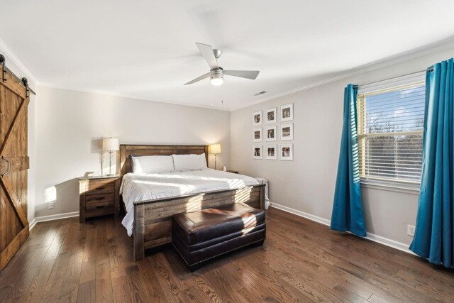 bedroom with ceiling fan, a barn door, dark wood-type flooring, and ornamental molding