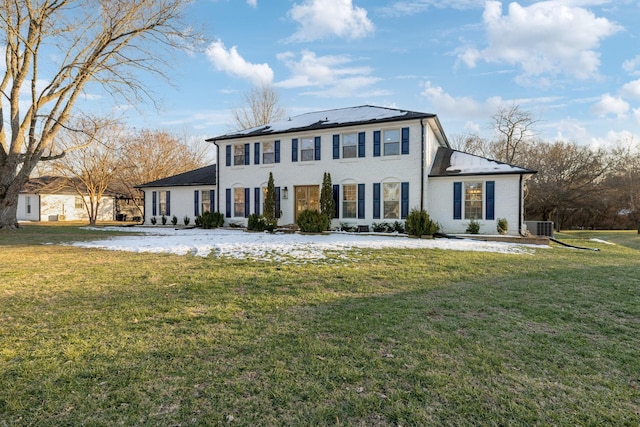 colonial-style house with a front yard, solar panels, and central AC