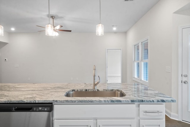 kitchen with light stone countertops, white cabinetry, sink, ceiling fan, and stainless steel dishwasher