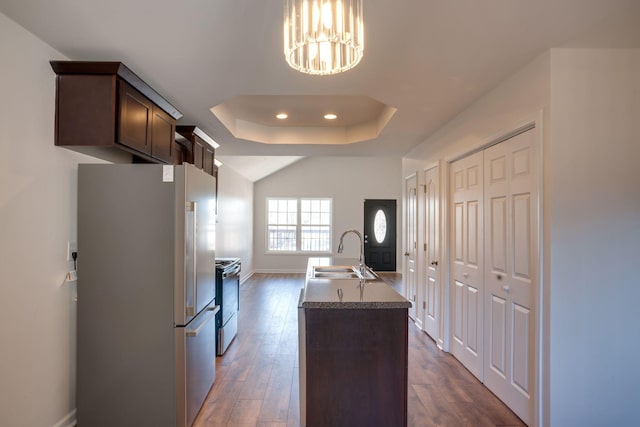 kitchen featuring sink, dark wood-type flooring, appliances with stainless steel finishes, dark brown cabinetry, and a raised ceiling