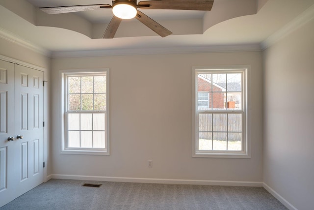 empty room featuring a healthy amount of sunlight, carpet flooring, and crown molding