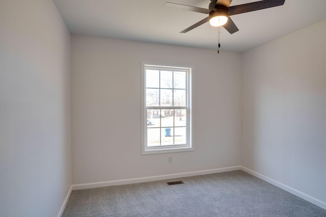 empty room with carpet flooring, a wealth of natural light, and ceiling fan