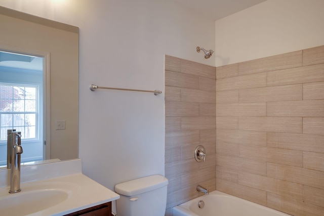 full bathroom featuring tiled shower / bath, vanity, and toilet