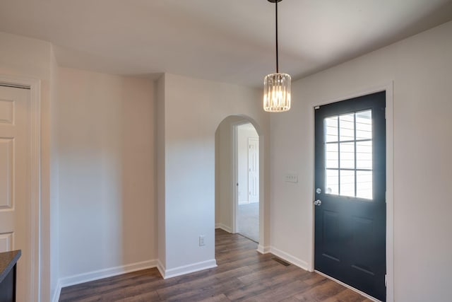 foyer featuring dark hardwood / wood-style flooring and an inviting chandelier