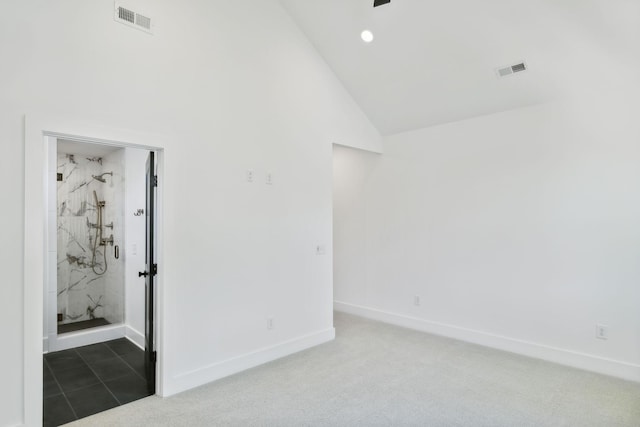 tiled spare room featuring vaulted ceiling