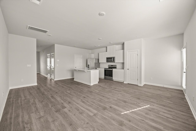 unfurnished living room featuring light wood-type flooring and a healthy amount of sunlight