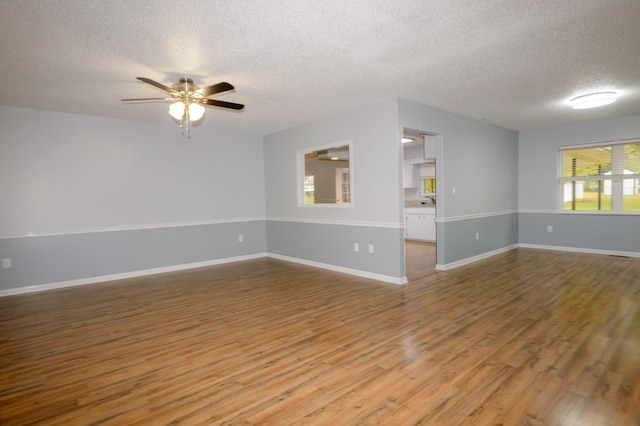 unfurnished room with a textured ceiling, ceiling fan, and hardwood / wood-style flooring