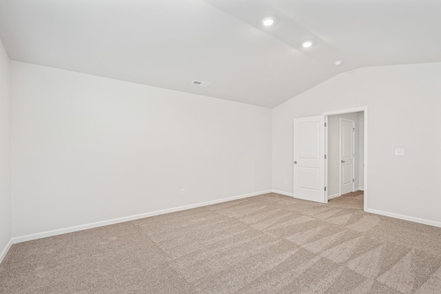 carpeted empty room with lofted ceiling