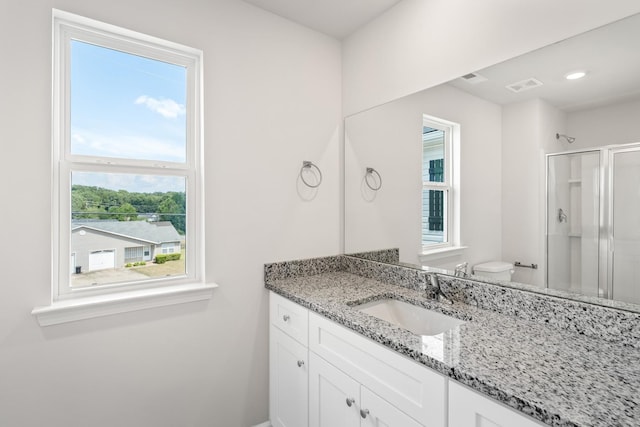 bathroom with toilet, walk in shower, and vanity