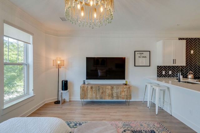 living room with plenty of natural light, sink, and ornamental molding