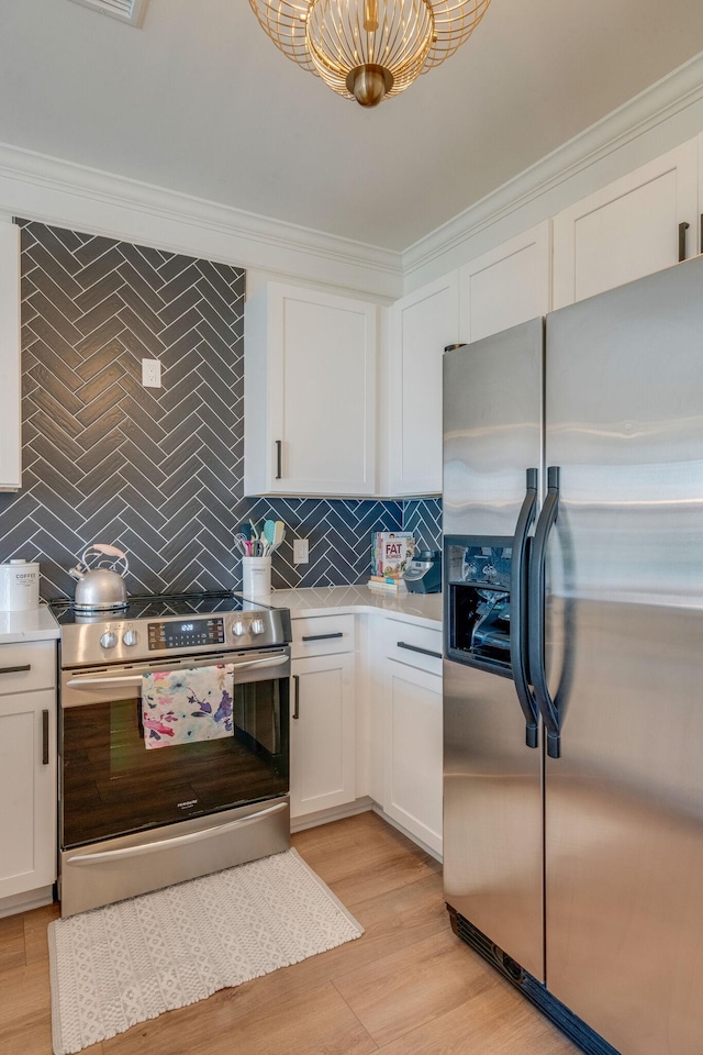 kitchen with white cabinetry, stainless steel appliances, backsplash, light wood-type flooring, and crown molding