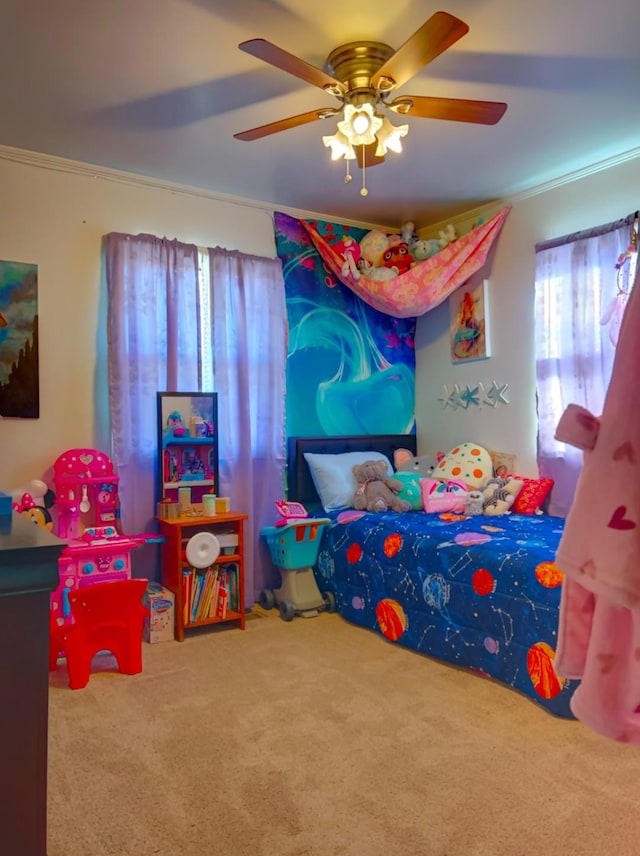 carpeted bedroom featuring ceiling fan and ornamental molding