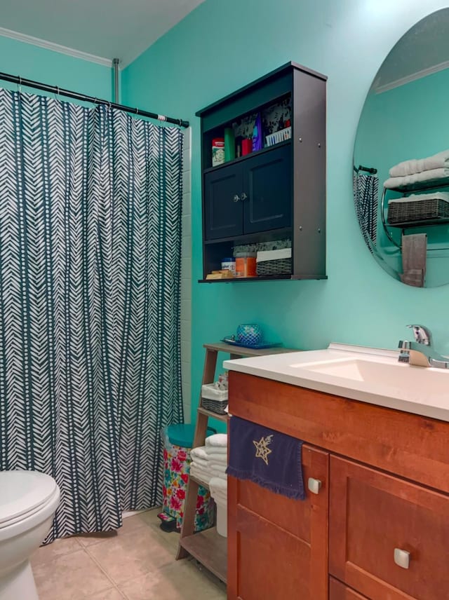 bathroom with toilet, vanity, tile patterned flooring, and crown molding