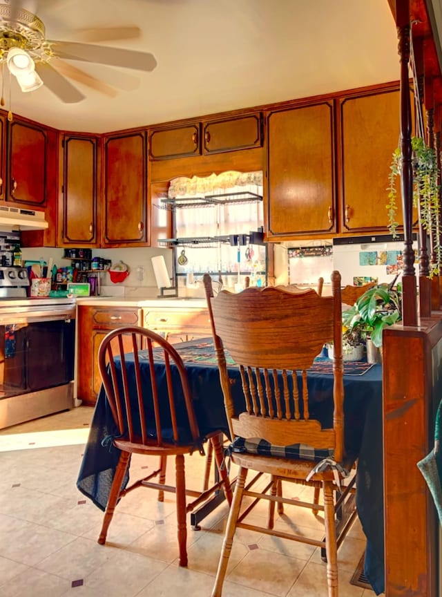 kitchen featuring ceiling fan, electric range, and light tile patterned floors